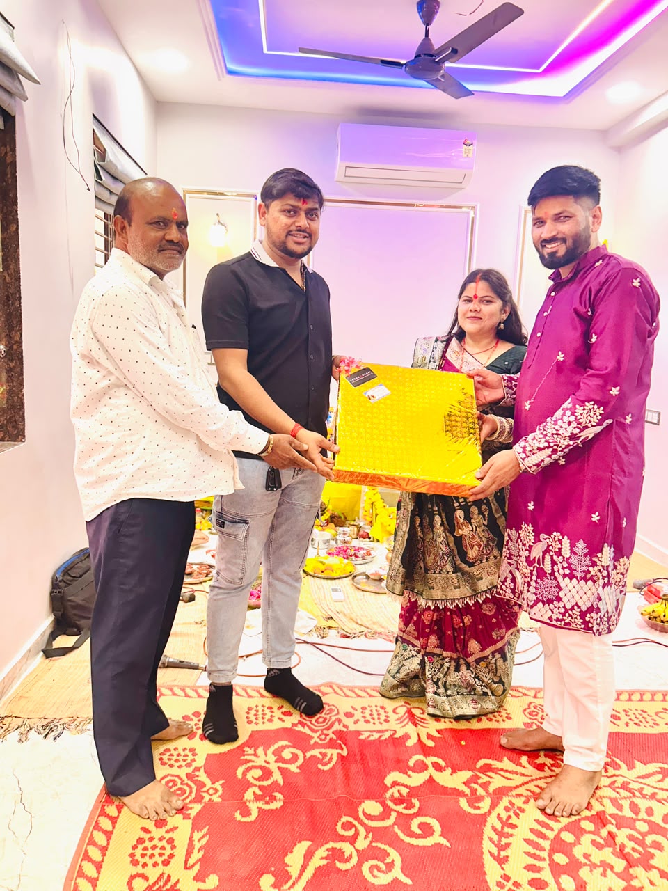 Sarvamangal team celebrating with a couple holding a gold-wrapped gift